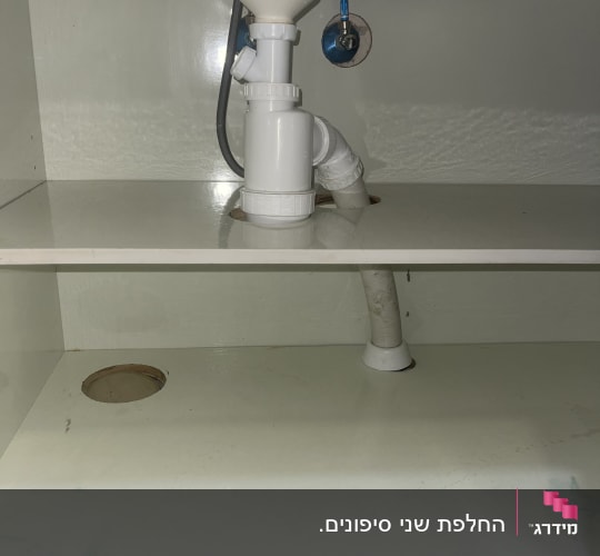 צנרת מתחת לכיור עם ברזים וחיבורים